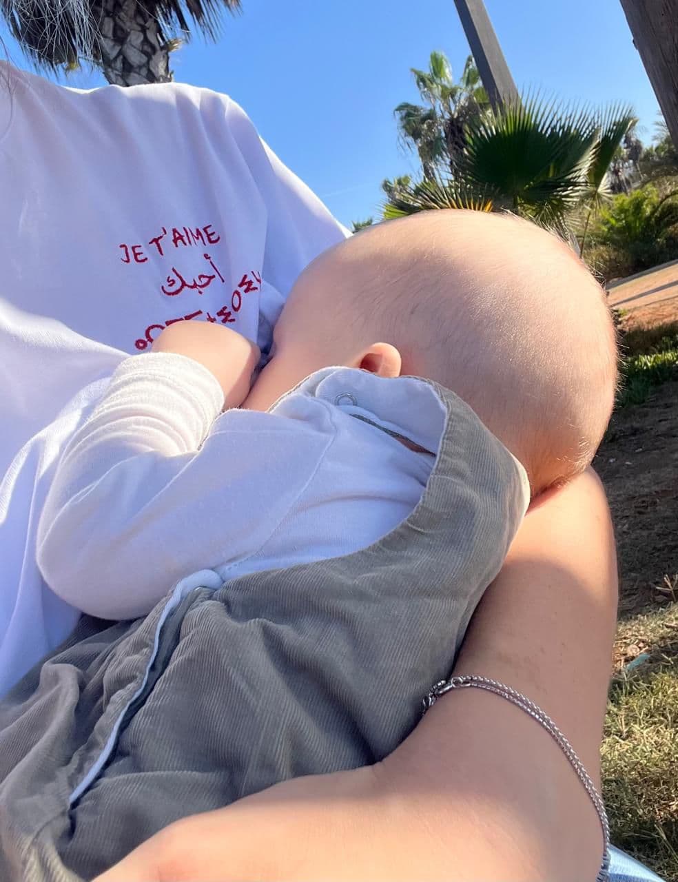 Maman allaitant son bébé dehors avec un t-shirt J'allète Je t'aime